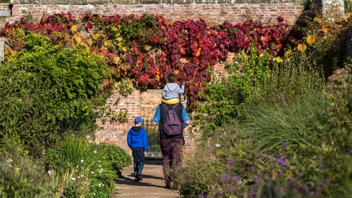 Family walking through the walled kitchen garden at Beningbrough Hall, Gallery and Gardens, North Yorkshire